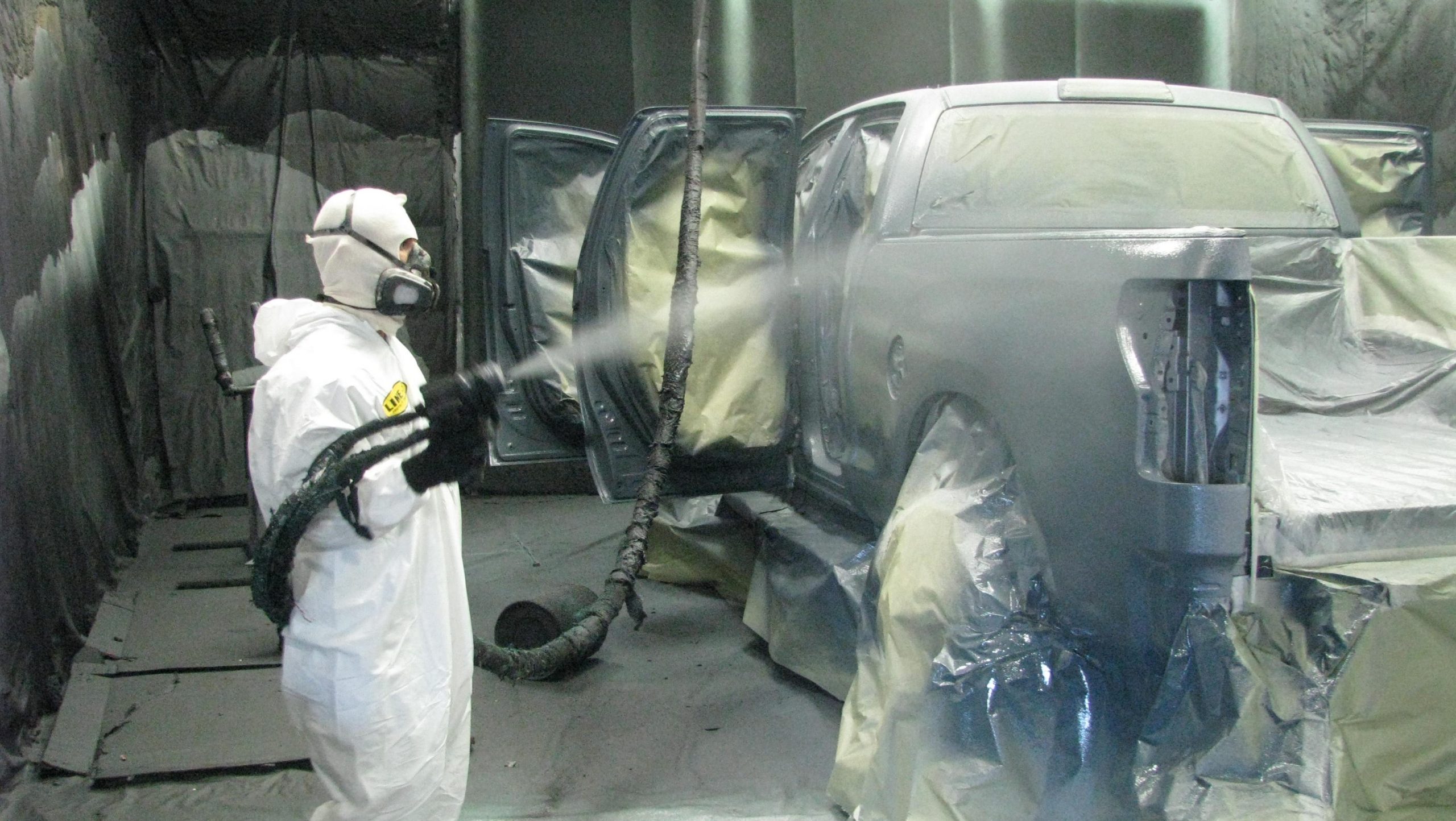 A professional doing a bedliner paint job