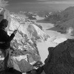 man standing on mountain with two-way radio