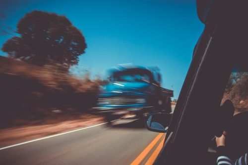 blurred blue truck passing through another vehicle