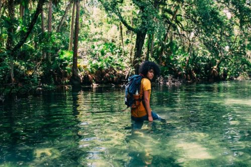 person wearing a backpack and a body of water