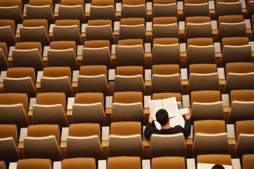 lone man in a room full of chairs