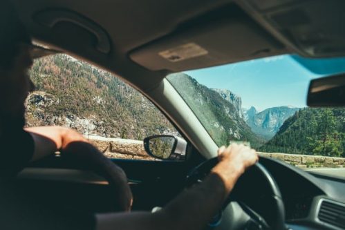 man driving with one arm on window