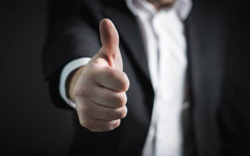 man in suit giving the thumbs up