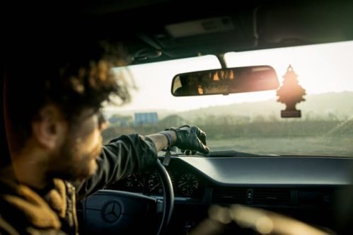 man inside car with reflection through mirror