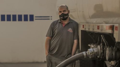 man with mask standing beside truck