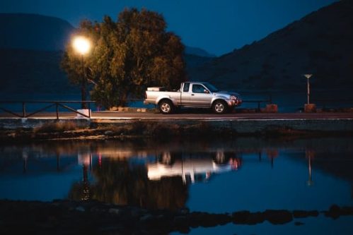 moving pickup truck with reflection on water