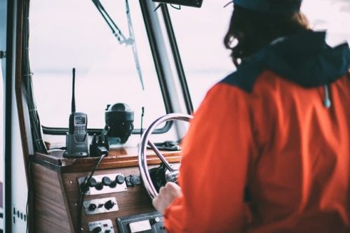 person holding steering wheel beside a two-way radio
