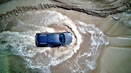 top view photo of a blue pick-up truck driven on a puddle of water