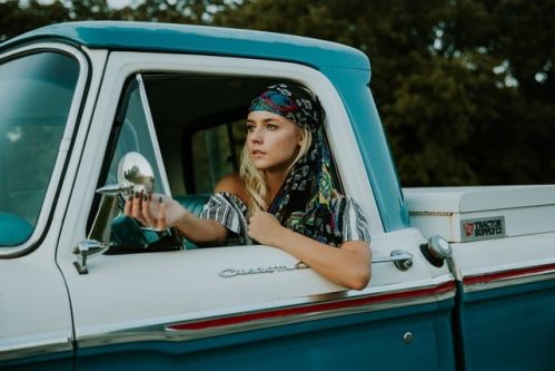 woman leaning on window of truck