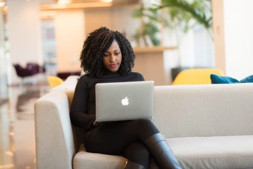 woman sitting on a couch with a laptop